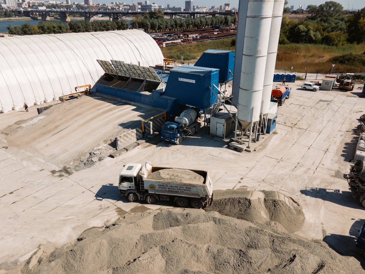 An aerial view of an active construction site with trucks and machinery in Novosibirsk, Russia.